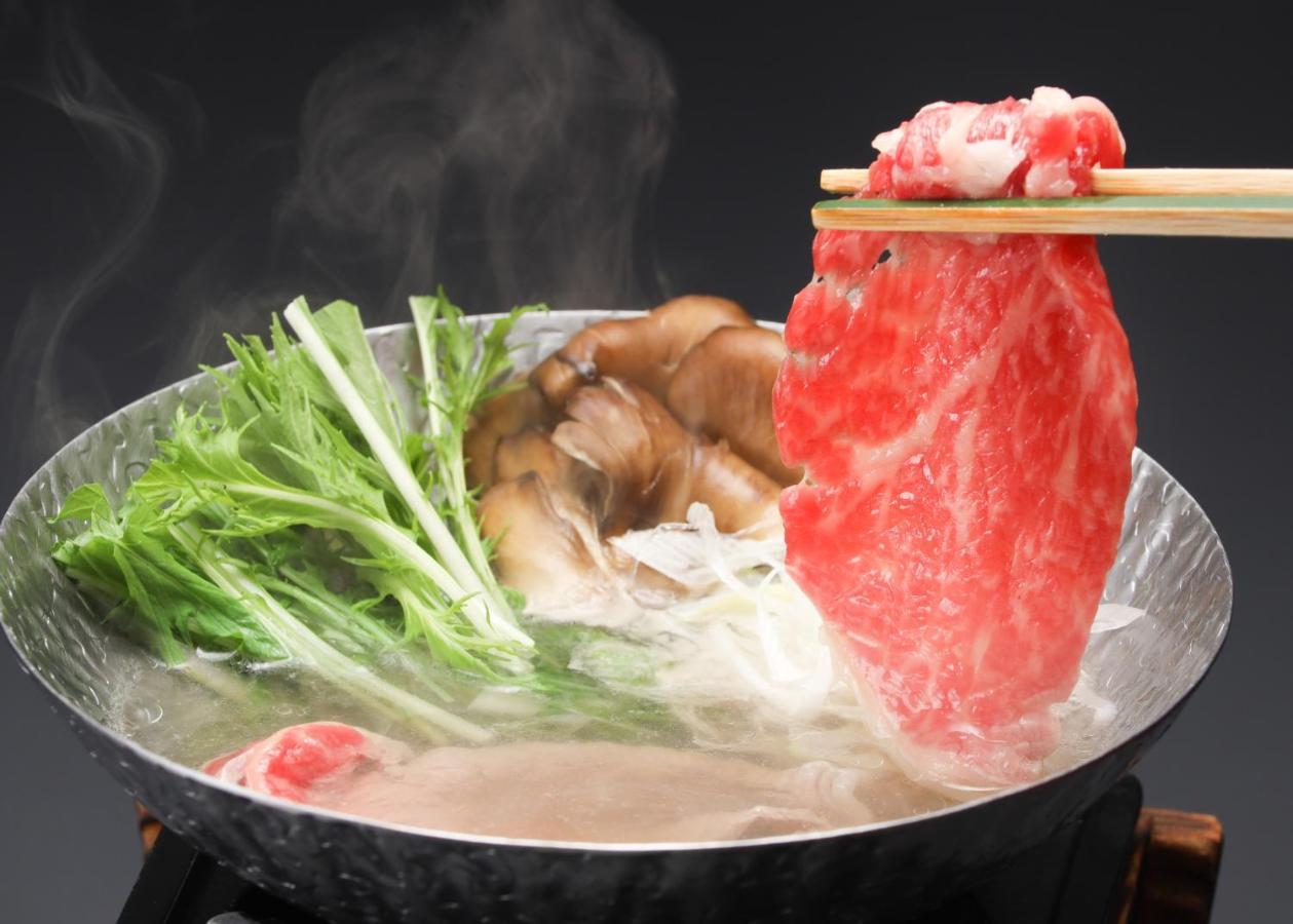스이메이칸 게로 외부 사진 A piece of marbled beef being dipped into a pot of soup